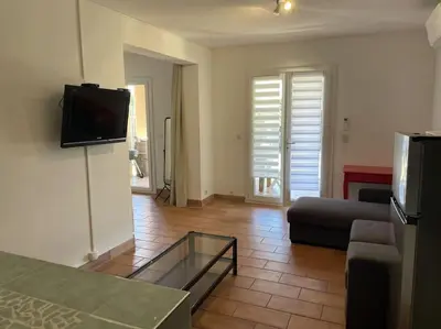 a living room with a couch and a tv at Rez de villa bordure Ajaccio in Ajaccio