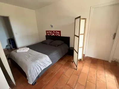 a small bedroom with a bed and a mirror at Rez de villa bordure Ajaccio in Ajaccio