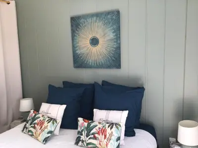 a bed with blue pillows and a picture above it at casa turchina chambre avec piscine privée in Porto-Vecchio