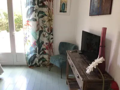 a living room with a tv and a table and chairs at casa turchina chambre avec piscine privée in Porto-Vecchio