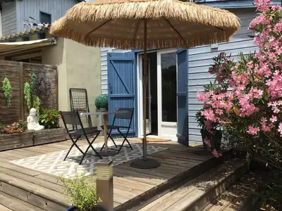 a patio with a table and chairs and an umbrella at casa turchina chambre avec piscine privée in Porto-Vecchio