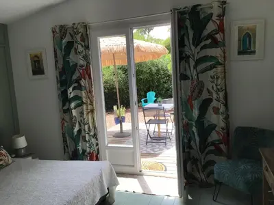 a room with a door open to a patio with a table at casa turchina chambre avec piscine privée in Porto-Vecchio