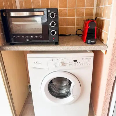 a microwave and a washing machine on a counter at Domaine Mare e Monti - T1 Les Palmiers vue mer in Albitreccia
