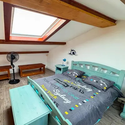 a bedroom with a blue bed with a window at Domaine Mare e Monti - T2 Les Oliviers vue mer in Albitreccia