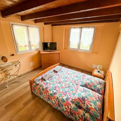 a bedroom with a bed and a dresser and two windows at Domaine Mare e Monti - T2 Les Oliviers vue mer in Albitreccia