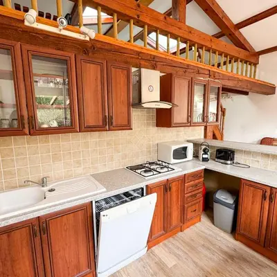 a kitchen with wooden cabinets and white appliances at Domaine Mare e Monti - T2 Les Oliviers vue mer in Albitreccia