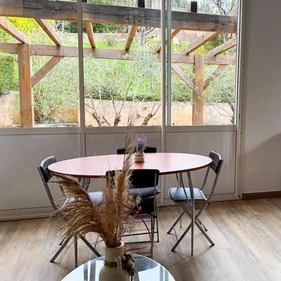 a table and chairs in a room with a large window at Domaine Mare e Monti - T2 Les Oliviers vue mer in Albitreccia