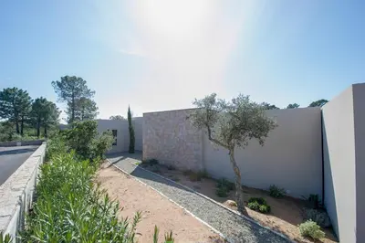 a wall with a tree next to a building at Villa calme luxueuse et proche plage saint-cyprien in Lecci
