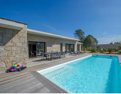 a house with a swimming pool and a wooden deck at Villa calme luxueuse et proche plage saint-cyprien in Lecci
