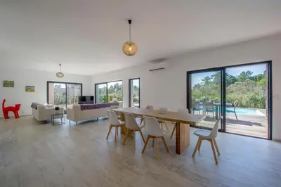 a living room with a wooden table and chairs at Villa calme luxueuse et proche plage saint-cyprien in Lecci