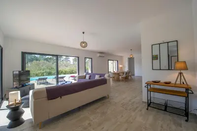 a large living room with a couch and a table at Villa calme luxueuse et proche plage saint-cyprien in Lecci