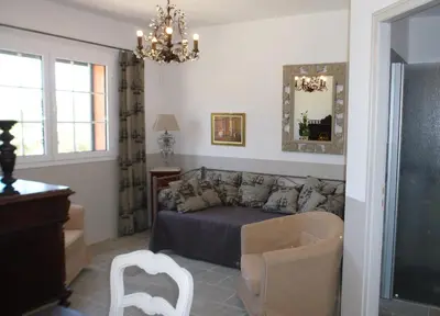 a bedroom with a bed and a couch and a chandelier at Villa Primavera in Galeria