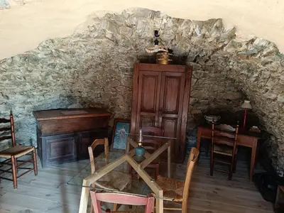 a room with a table and chairs and a piano at A Chjusella di E Sertine in Tralonca