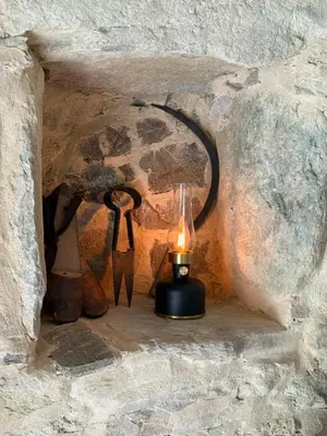 a lamp in a stone wall with a candle at A Chjusella di E Sertine in Tralonca