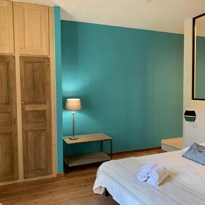 a bedroom with a blue wall and a bed with towels at CASA CITADELLA Bonifacio in Bonifacio