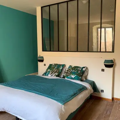 a bedroom with a bed with a blue wall at CASA CITADELLA Bonifacio in Bonifacio