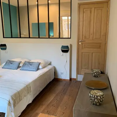 a bedroom with a bed and a table and a door at CASA CITADELLA Bonifacio in Bonifacio