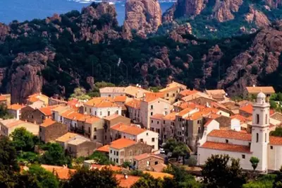 a town on a hill with mountains in the background at FUNTANA NOVA in Piana
