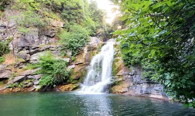 a waterfall in the middle of a pool of water at Maison U nidu à 500m de la mer in Cervione