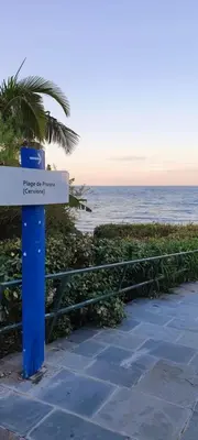 a sign on the beach with the ocean in the background at Maison U nidu à 500m de la mer in Cervione