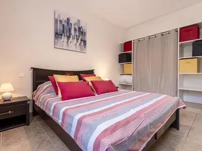 a bedroom with a large bed with red pillows at Apartment Muratello by Interhome in Porto-Vecchio