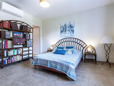 a bedroom with a bed and a book shelf with books at Apartment Muratello by Interhome in Porto-Vecchio