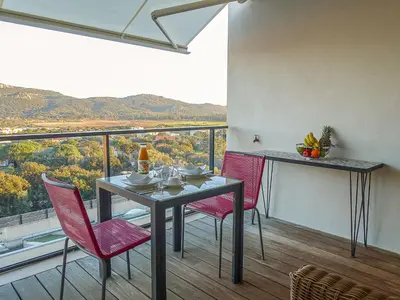 a dining room with a table and chairs on a balcony at Studio Château-20 by Interhome in Porto-Vecchio