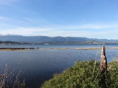 a large body of water with mountains in the background at Apartment Paoli by Interhome in Porto-Vecchio