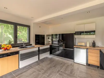 a large kitchen with black and white appliances at Apartment Paoli by Interhome in Porto-Vecchio
