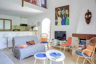 a living room with a couch and chairs and a tv at Villa Bossangoa in Cervione
