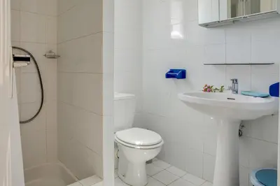 a white bathroom with a toilet and a sink at Villa Bossangoa in Cervione