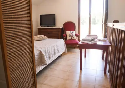 a bedroom with a bed and a desk and a television at Villa Bossangoa in Cervione