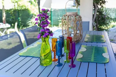 a table with colorful vases and flowers on it at Villa Bossangoa in Cervione