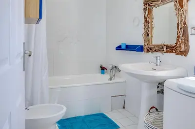 a bathroom with a sink and a toilet and a mirror at Villa Bossangoa in Cervione
