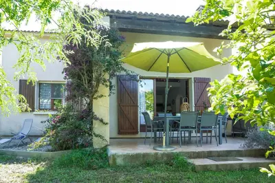 a patio with a table and chairs and an umbrella at Villa Bossangoa in Cervione