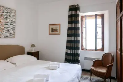 a bedroom with a bed and a chair and a window at I MONTI SIGNORI in Porto Ota