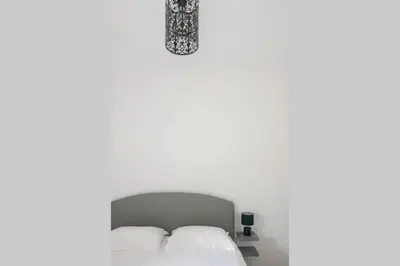 a bedroom with two white beds and a chandelier at I MONTI SIGNORI in Porto Ota