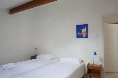 a white bedroom with a bed and a blue picture on the wall at I MONTI SIGNORI in Porto Ota