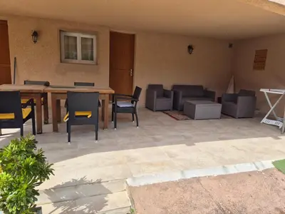 a patio with a wooden table and chairs at Bel appartement dans hameau calme in Bonifacio