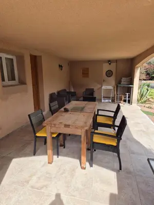 a wooden table and chairs in a room at Bel appartement dans hameau calme in Bonifacio