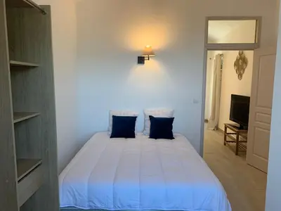 a bedroom with a white bed with blue pillows at Casa Lisà in Sartène