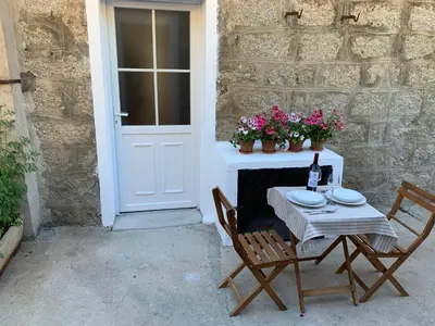 a table with two chairs and a bottle of wine on it at Casa Lisà in Sartène