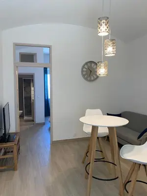 a living room with a table and chairs and a clock at Casa Lisà in Sartène