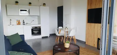 a living room with a couch and a table and a kitchen at Appartement 2 pièces dans le centre historique de Porto Vecchio in Porto-Vecchio
