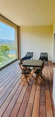 a wooden deck with a table and chairs on it at Appartement 2 pièces dans le centre historique de Porto Vecchio in Porto-Vecchio