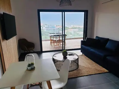a living room with a couch and a table at Appartement 2 pièces dans le centre historique de Porto Vecchio in Porto-Vecchio
