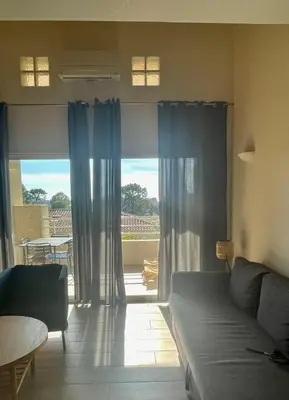 a living room with a couch and a large window at APPARTEMENT DUPLEX PORTICCIO Centre in Porticcio