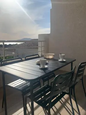 a black table with two cups and chairs on a balcony at APPARTEMENT DUPLEX PORTICCIO Centre in Porticcio