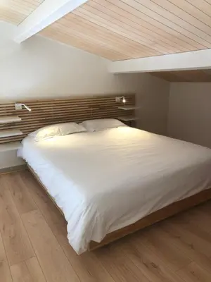 a large white bed in a bedroom with a wooden ceiling at APPARTEMENT DUPLEX PORTICCIO Centre in Porticcio