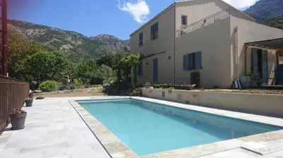 a swimming pool in front of a house at Villa Capraghjese in Galeria